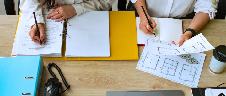 Zdjęcie przedstawia osoby przygotowujące dokumenty