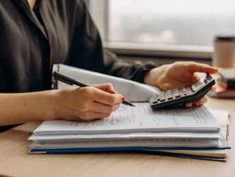 Zdjęcie przedstawiające osobe z laptopem siedzącą na kanapie